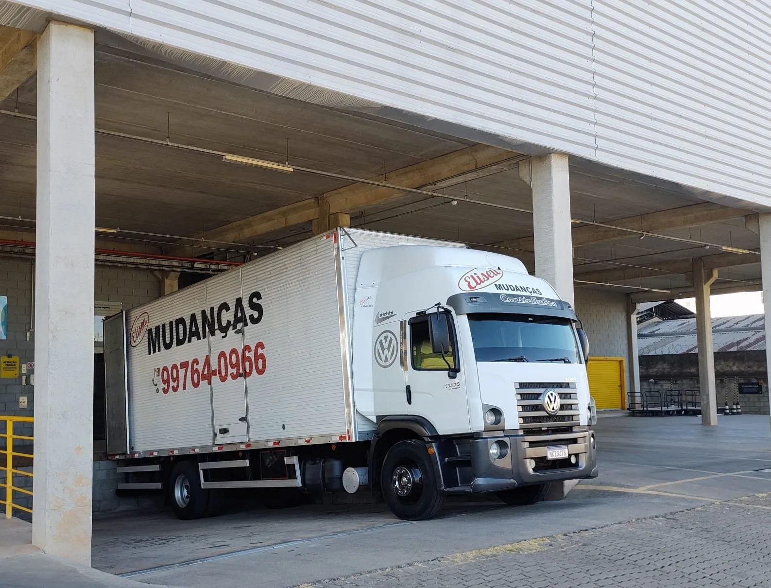 Caminhão baú da Eliseu Mudanças na doca de um galpão comercial
