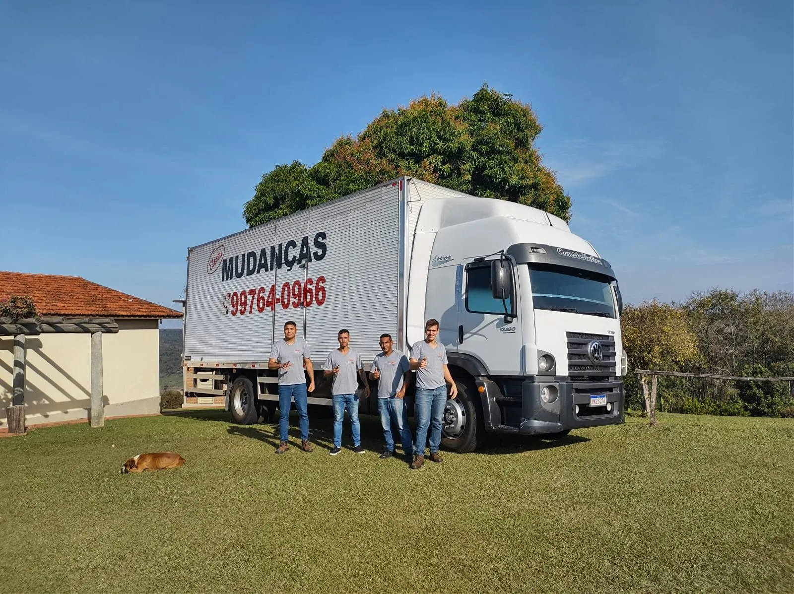 Equipe própria da Eliseu Mudanças ao lado de um caminhão baú da frota