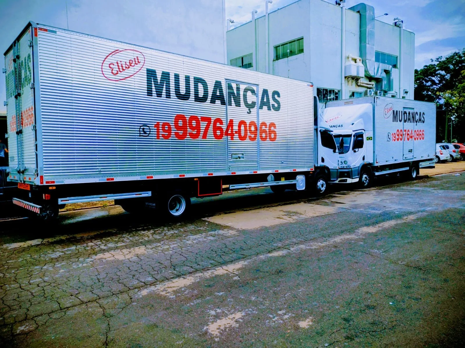 Dois caminhões baú da Eliseu com o WhatsApp (19) 99764-0966 pintado no baú