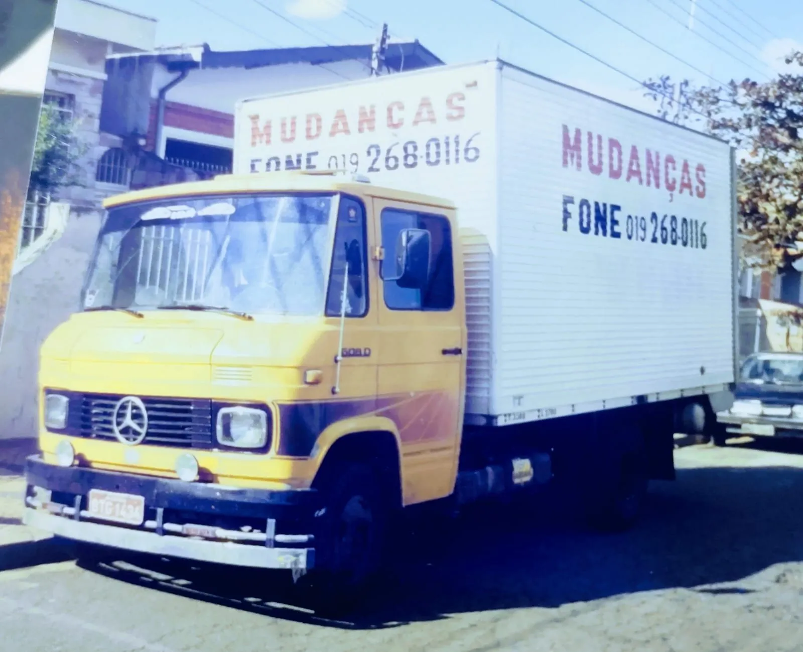 Caminhão Mercedes-Benz 608D de cabine amarela e baú branco com o nome Mudanças