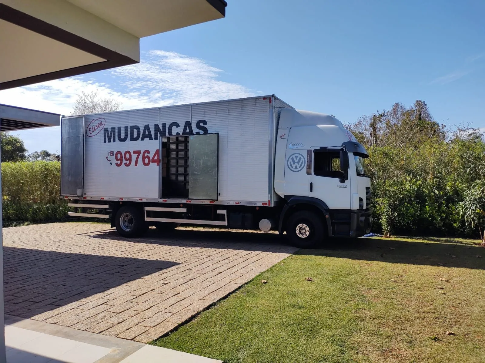 Caminhão baú da Eliseu Mudanças estacionado em frente a uma residência